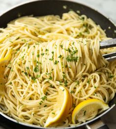 a pan filled with pasta and lemon slices