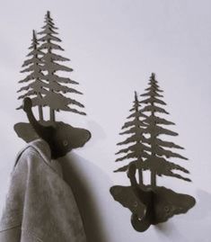 two metal moose hooks hang on the wall next to some tree shaped trees in black and white