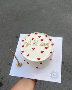 a white cake with red hearts on it