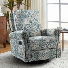 a blue and white chair sitting on top of a rug in a living room next to a window