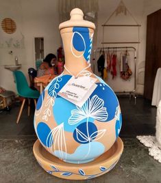 a blue and white vase sitting on top of a wooden stand next to a table