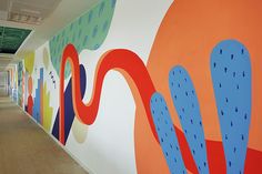 an office hallway with colorful murals on the wall