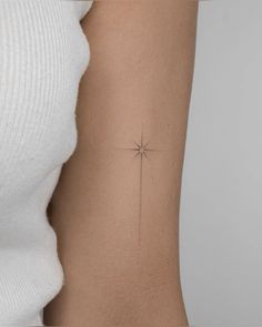 a woman's arm with a small star tattoo on it