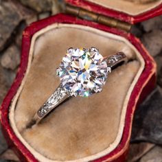 an old diamond ring sits in its velvet case