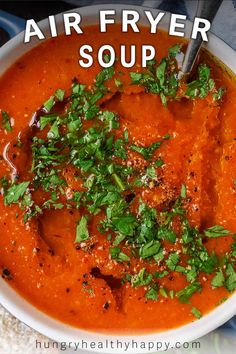 a white bowl filled with red soup and garnished with parsley on top