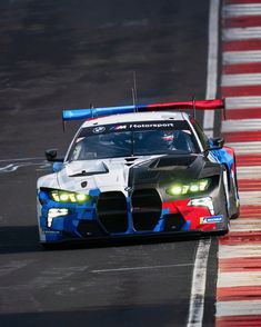 a car driving on a race track with its lights on