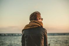 a person standing on the beach looking out at the water