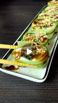 cucumbers with sauce and chopsticks sitting on a white plate, ready to be eaten