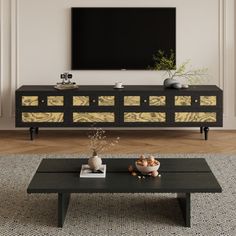 a living room with a large television on top of a wooden shelf next to a coffee table