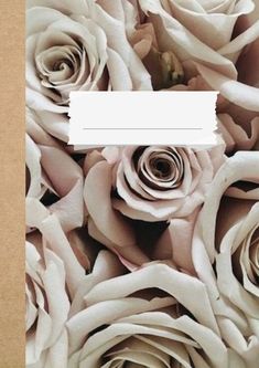 a bunch of white roses in a box with a piece of paper taped to it