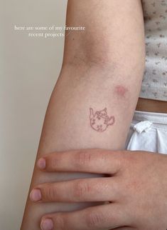 a woman's arm with a small tattoo on the left side of her arm