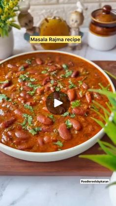 a bowl filled with chili and beans on top of a wooden cutting board