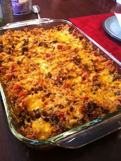 a casserole dish is sitting on a table with plates and utensils