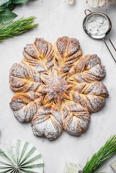 an overhead view of a pastry with powdered sugar on top, surrounded by greenery