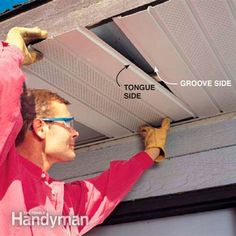 a man wearing safety goggles is fixing the gutter cover on a garage door