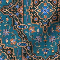 a blue and orange rug with an intricate design on the bottom, in front of a black background