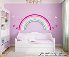 a child's bedroom with a rainbow wall decal