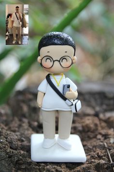 a small figurine is standing on the ground with a camera in his hand