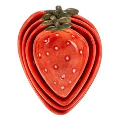 a stack of red ceramic plates topped with a strawberry