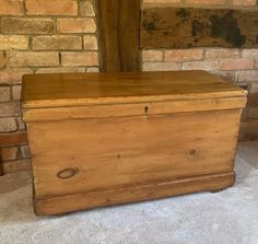 an old wooden chest sitting in front of a brick wall