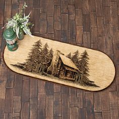 a wooden floor mat with a house and trees on it