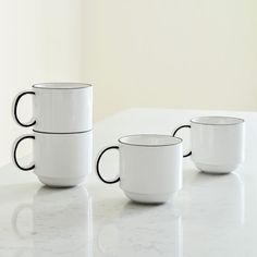 three black and white coffee cups sitting on top of a table