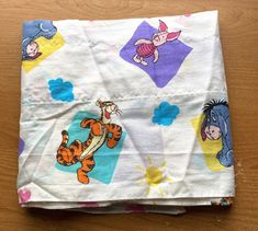 winnie the pooh and tigger fabric on a wooden surface