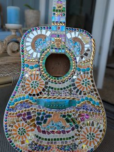 a colorful guitar is sitting on the floor