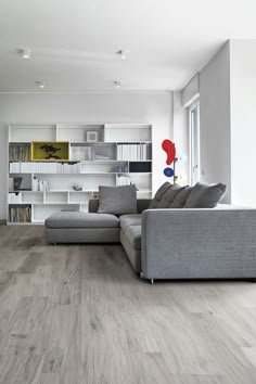 a modern living room with white walls and wood flooring is pictured in this image