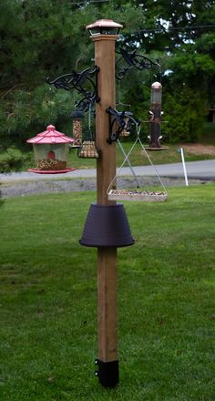 a wooden pole with bird feeders on it