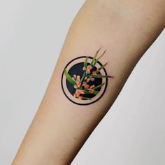 a person's arm with a tattoo on it that has flowers in the center