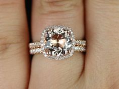 a woman's engagement ring with an oval shaped diamond and two smaller round diamonds on the band