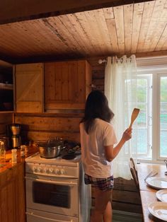 a woman standing in front of a stove top oven