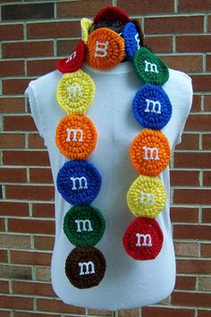 a white mannequin with multicolored beads and the letter m on it