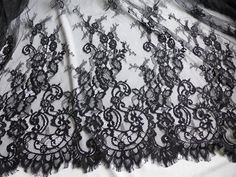 black lace on white fabric with an intricate design