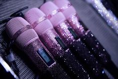 pink microphones lined up on top of each other in front of glitter covered walls