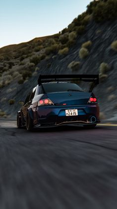 a blue sports car driving down the road