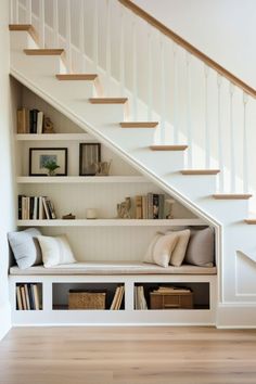 a white staircase with bookshelves under the stairs