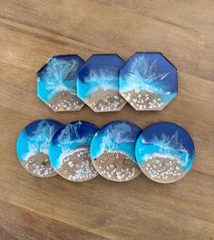 six blue and white plates with sand on them