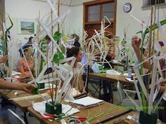 people sitting at desks working on crafts with paper streamers in front of them