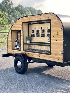 a small trailer is parked in the parking lot with its door open and shelves full of bottles