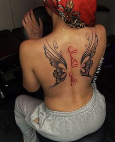 the back of a woman's body with tattoos on her upper and lower back