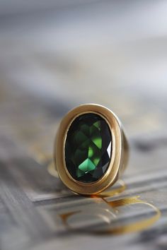 Vintage one-of-a-kind handcrafted solid 18k yellow gold bezel set ring featuring a very impressive natural green tourmaline gemstone in the center. The tourmaline is a deep rich green with a total carat weight of 11.65 carats measuring 20mm x 13mm. Ring size 6 1/2. The gold has a beautiful vintage brushed finish and was beautifully handcrafted in solid heavy 18k yellow gold. Hallmarked 18ct.  Your ring will arrive beautifully packaged with complimentary delivery via DHL express. Tracked, insured and signed for.  If you have any questions or need help with your order please send me a message and I will be happy to assist you. Oval Tourmaline Emerald Ring With Bezel Setting, Oval Tourmaline Emerald Ring In Yellow Gold, Handmade Tourmaline Gold Ring, Luxury Yellow Gold Tourmaline Rings, Gold Tourmaline Rings With Polished Finish, Tourmaline Bezel-set Oval Cabochon Ring, Handmade Green Tourmaline Gemstones, Vintage Brush, Bezel Set Ring