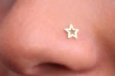 a close up of a person's nose with small gold stars on the side