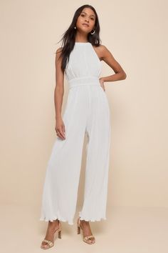 Shake up your event-ready looks with a picture-perfect outfit like the Lulus Flawless Mindset Ivory Satin Plisse Tie-Back Jumpsuit! Plisse-pleated woven satin shapes this elevated jumpsuit with a modified halter neckline (with back loop-button closures) and a fitted bodice with a smocked, banded waist. Relaxed, wide pant legs end at full length hems. Turn around to reveal a back cutout with a tying sash bow for an extra-femme finish! Elastic at back. Fit: This garment fits true to size. Length: Chic Sleeveless Jumpsuit For Wedding Guest, Sleeveless Jumpsuits And Rompers For Wedding Guest, Elegant Beach Jumpsuits And Rompers, Fitted Solid Color Jumpsuit For Wedding, Chic Spring Wedding Jumpsuits And Rompers, Elegant Solid Color Summer Jumpsuits And Rompers, Formal Halter Neck Jumpsuits And Rompers For Summer, Formal Halter Neck Jumpsuit For Summer, Chic Sleeveless Jumpsuit For Wedding