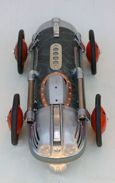 an old model race car is shown on the floor with red wheels and spokes