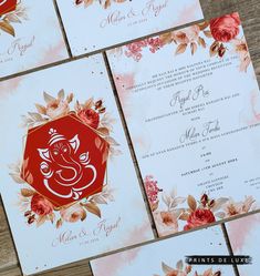 the wedding stationery is laid out on top of each other, with red and pink flowers