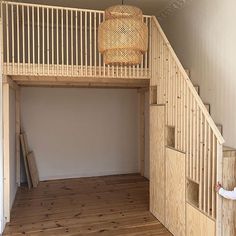 an empty room with stairs and a basket hanging from the ceiling over the top of it