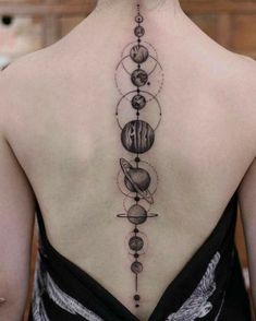 the back of a woman's neck with planets on it