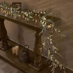 a wooden table topped with candles and greenery